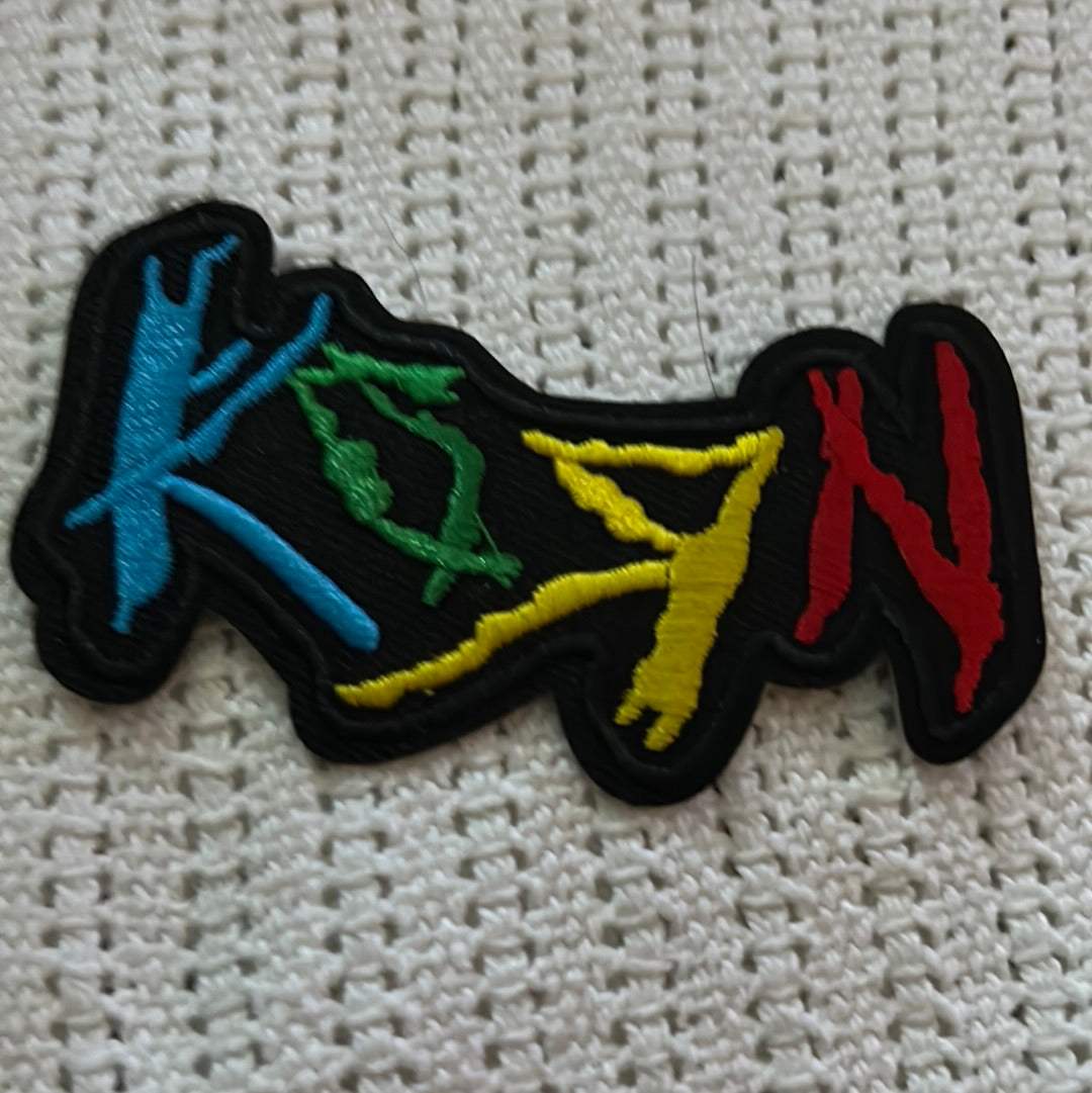 Embroidered KORN patch with colorful logo letters in blue, green, yellow, and red on black background for fans.