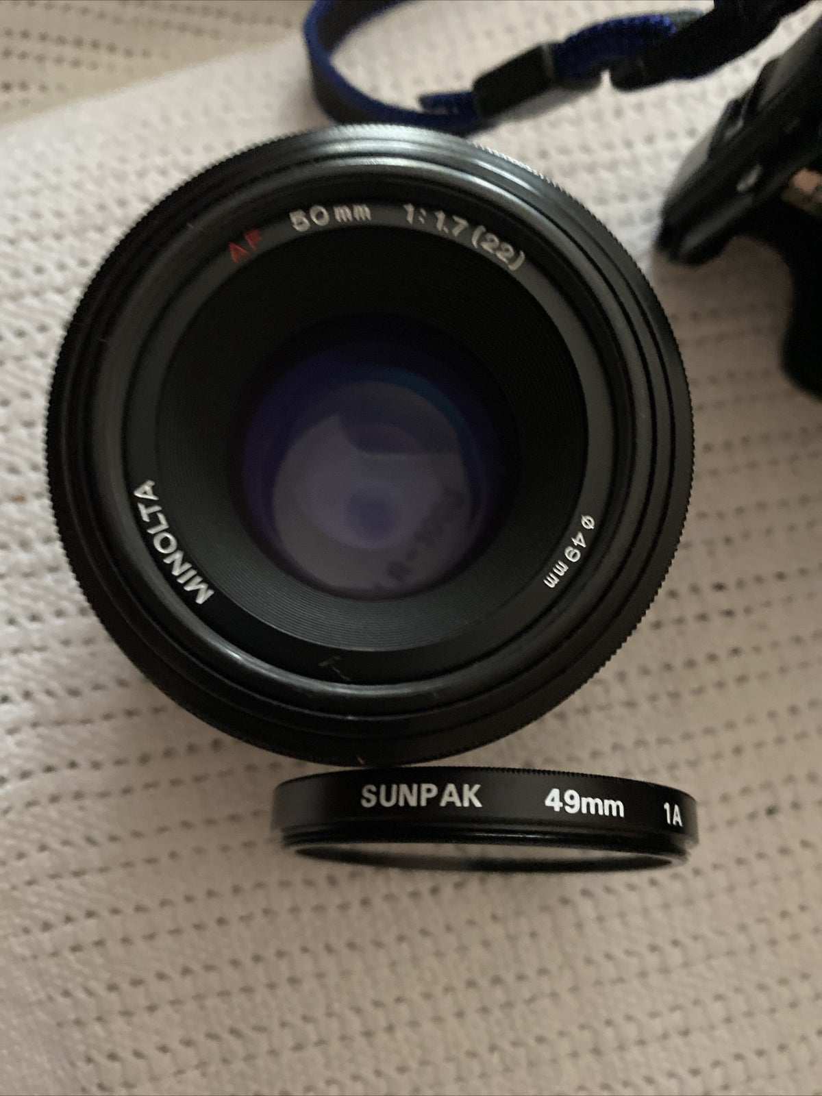 Minolta 7000 SLR 35mm black camera with 50mm f/1.7 lens and Milisi electronic flash, includes padded case and lens covers