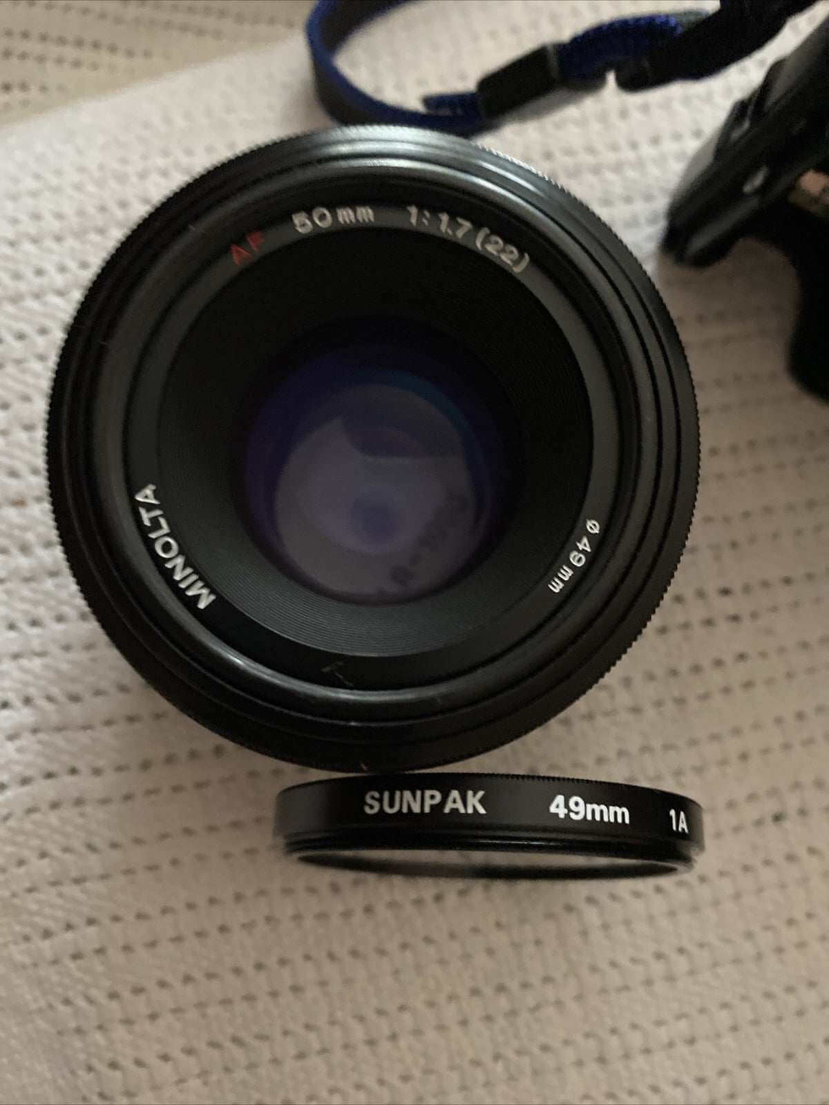 Minolta 7000 SLR 35mm black camera with 50mm f/1.7 lens and Milisi electronic flash, includes padded case and lens covers