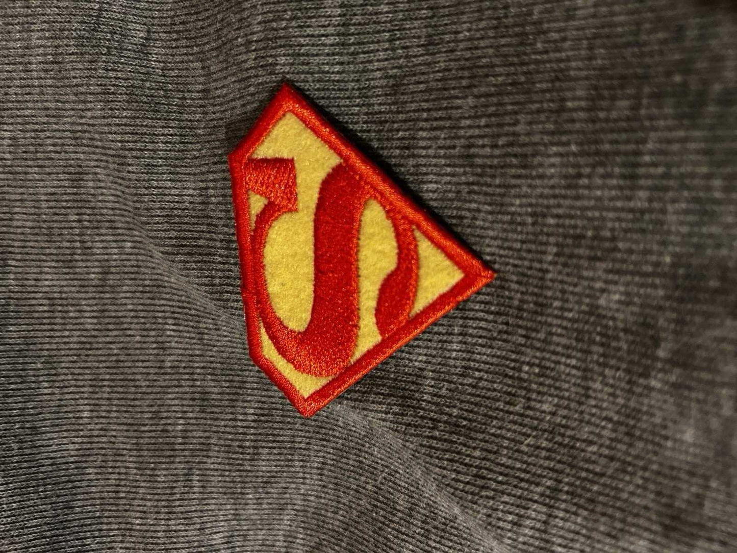 Vintage Superman embroidered patch on fabric background, featuring iconic logo design in bright colors.