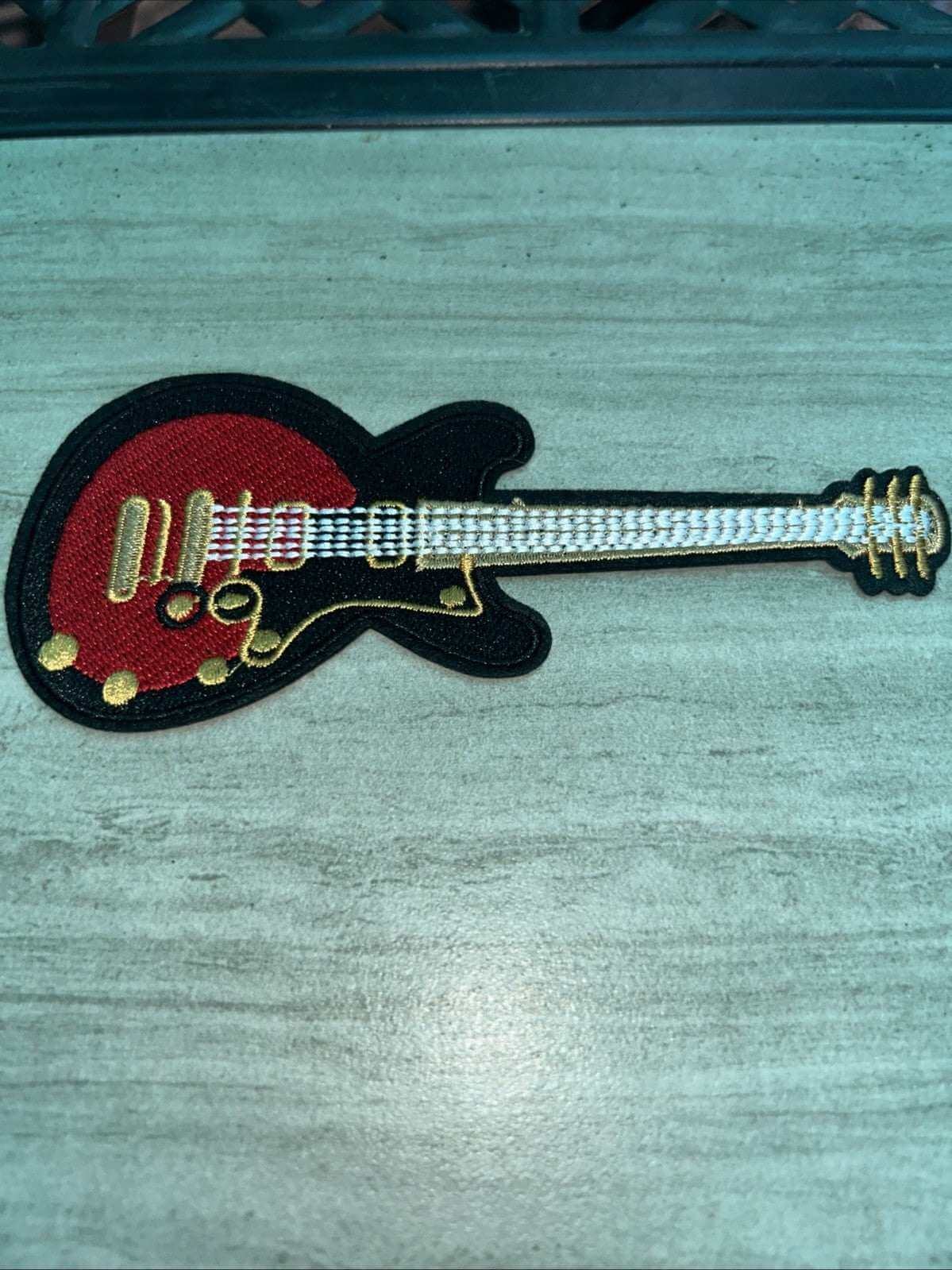 Embroidered red electric guitar iron-on patch for music-themed apparel and accessories