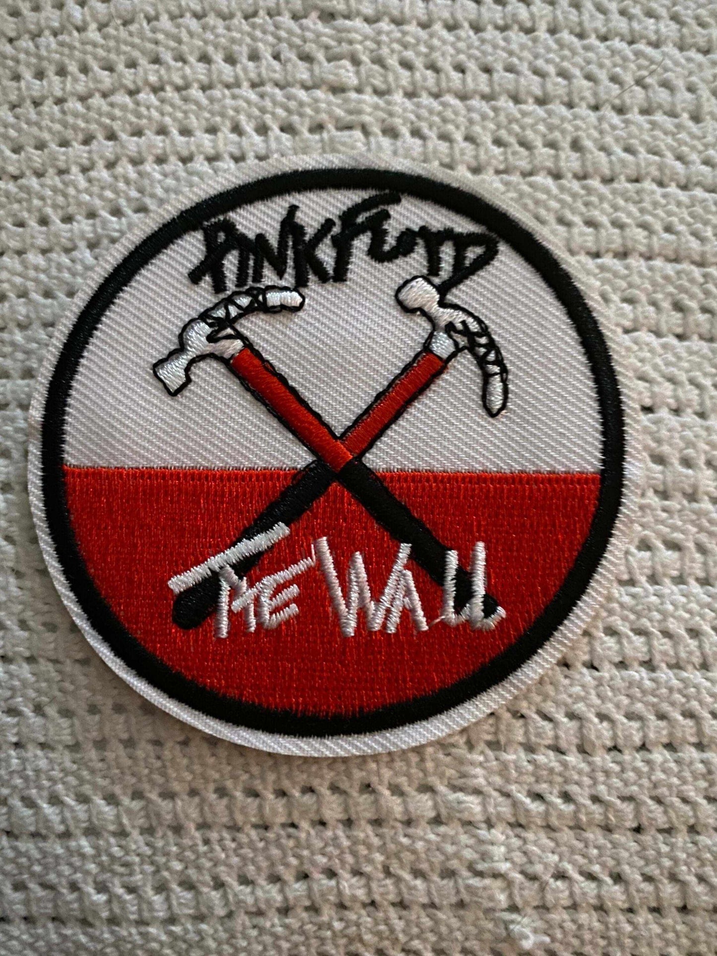 Pink Floyd The Wall round embroidered patch with crossed hammers design in red, white, and black, iron-on or sew-on, 3 inches diameter.