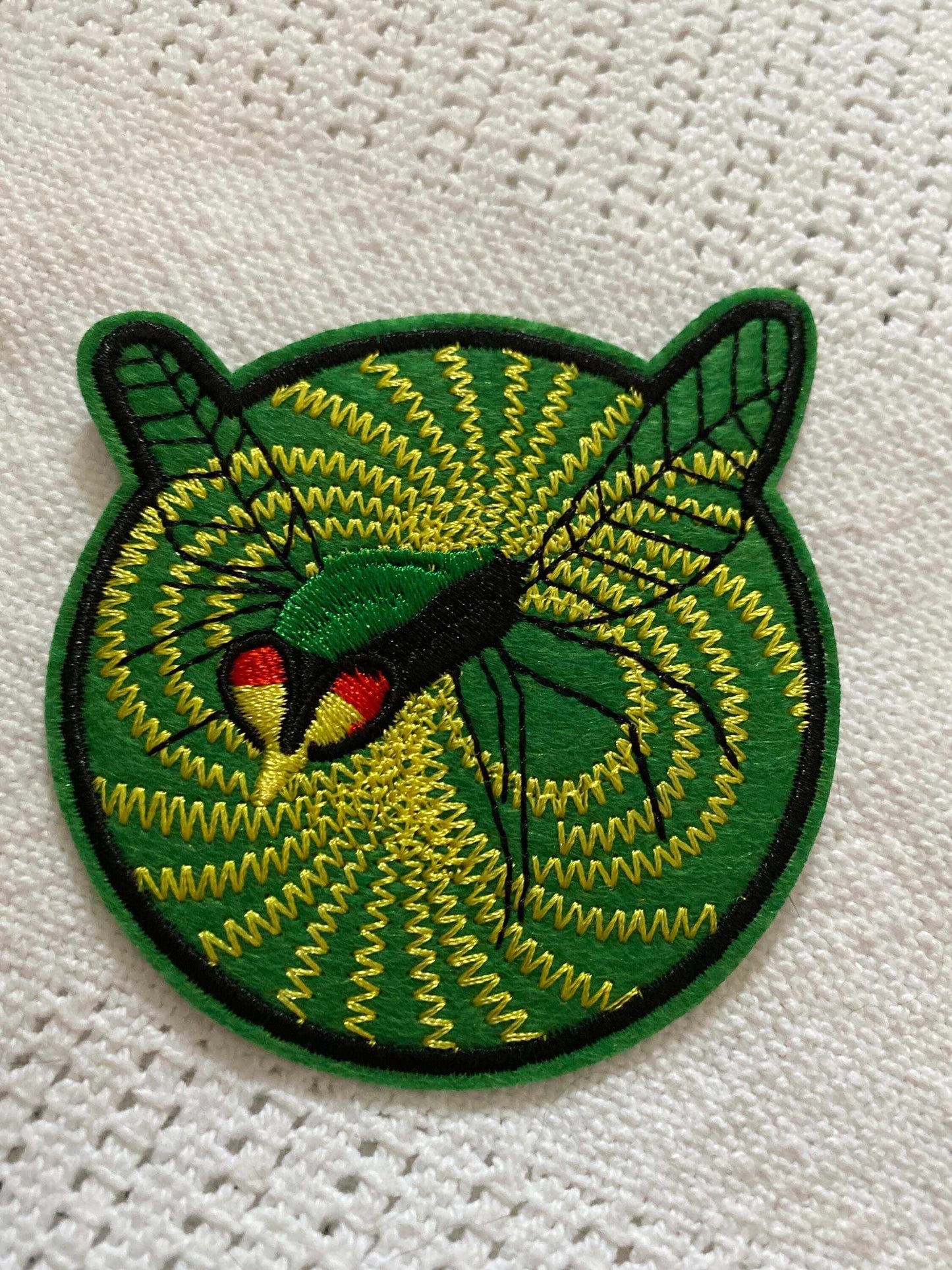Green Hornet 1967 TV show logo patch with green and yellow embroidered design on fabric background