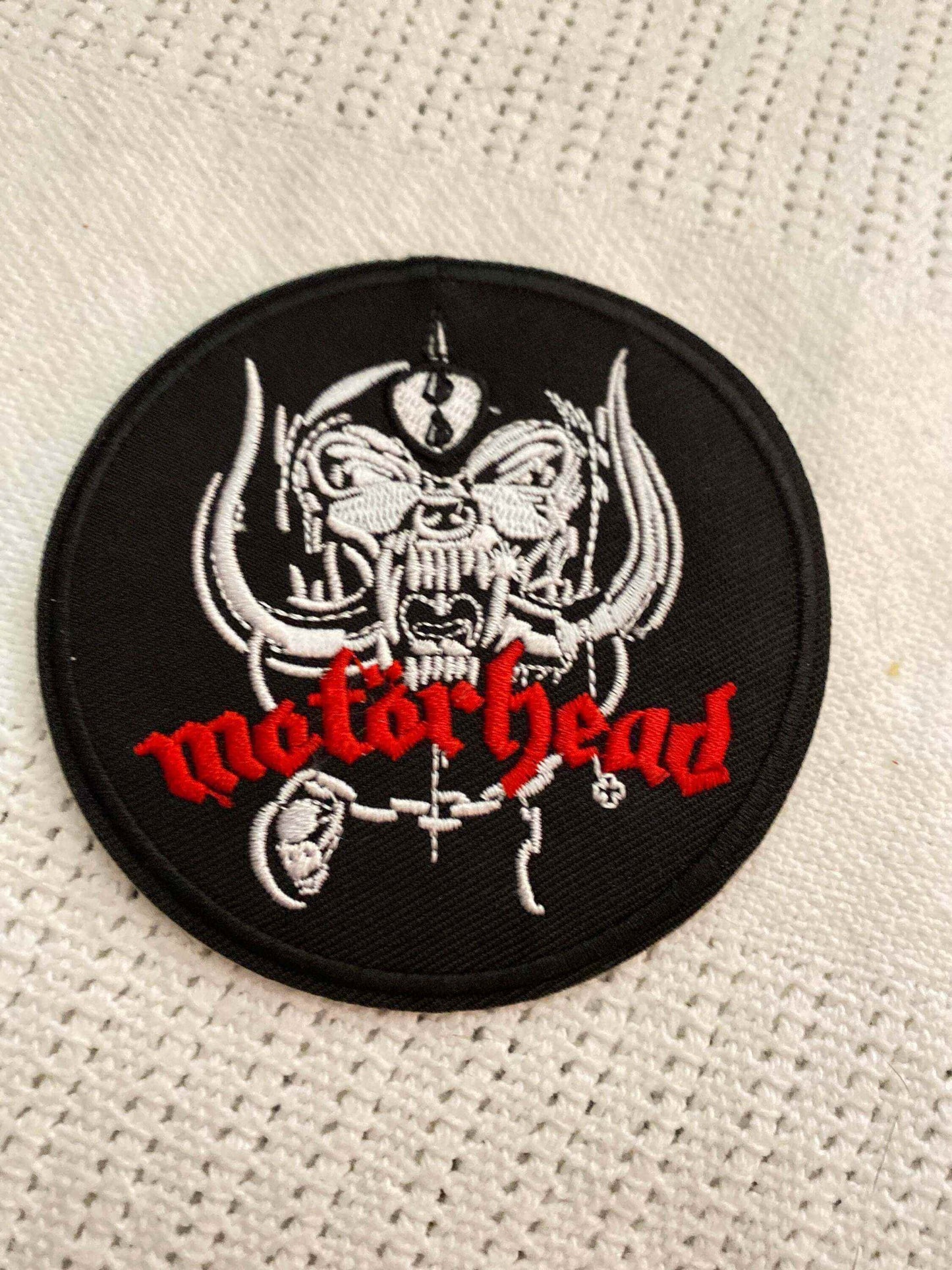 Black circular embroidered Motörhead patch with red band logo and white intricate war-pig design.