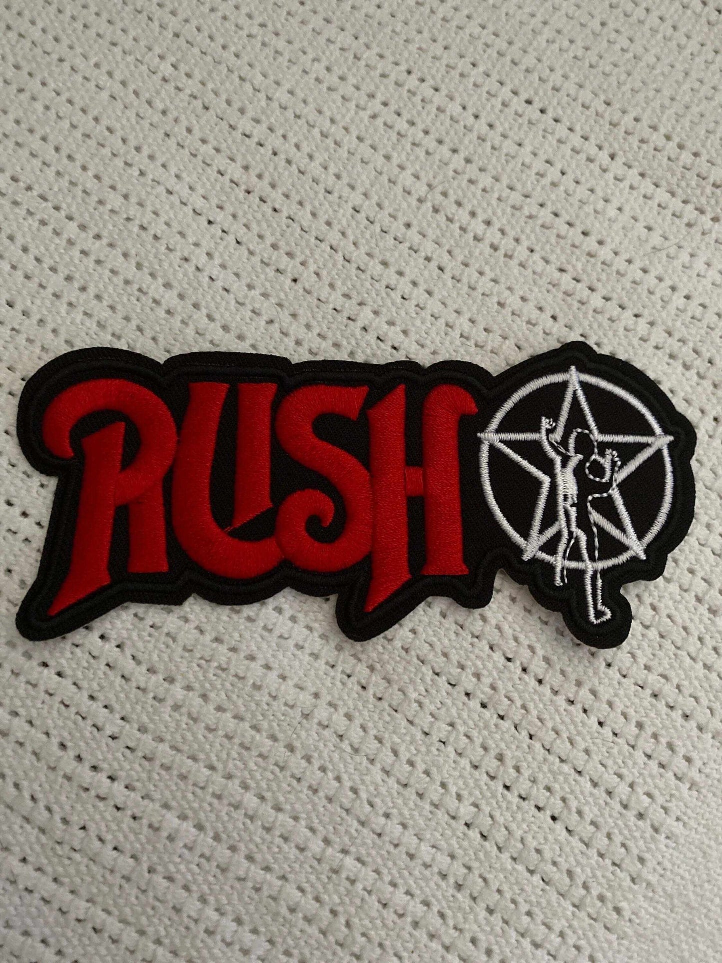 Rush logo patch with red lettering and white star man symbol on black background