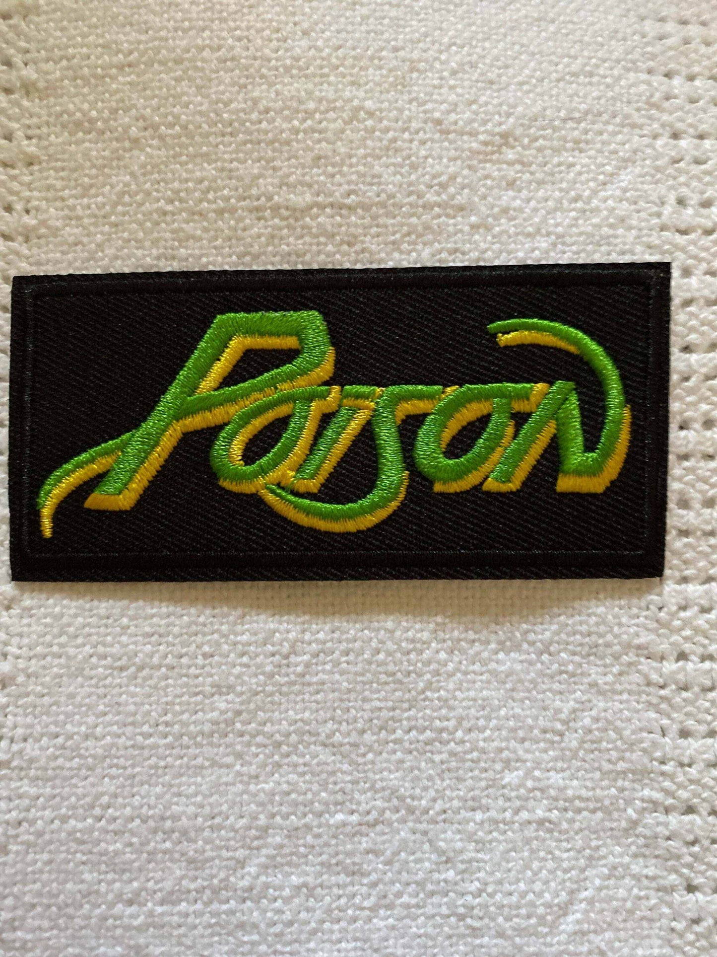 Poison logo patch flat embroidered in green and yellow on black background