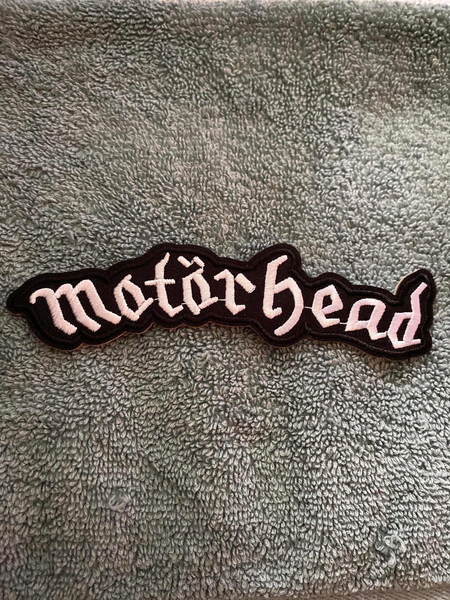 Motörhead logo embroidered patch on textured fabric background