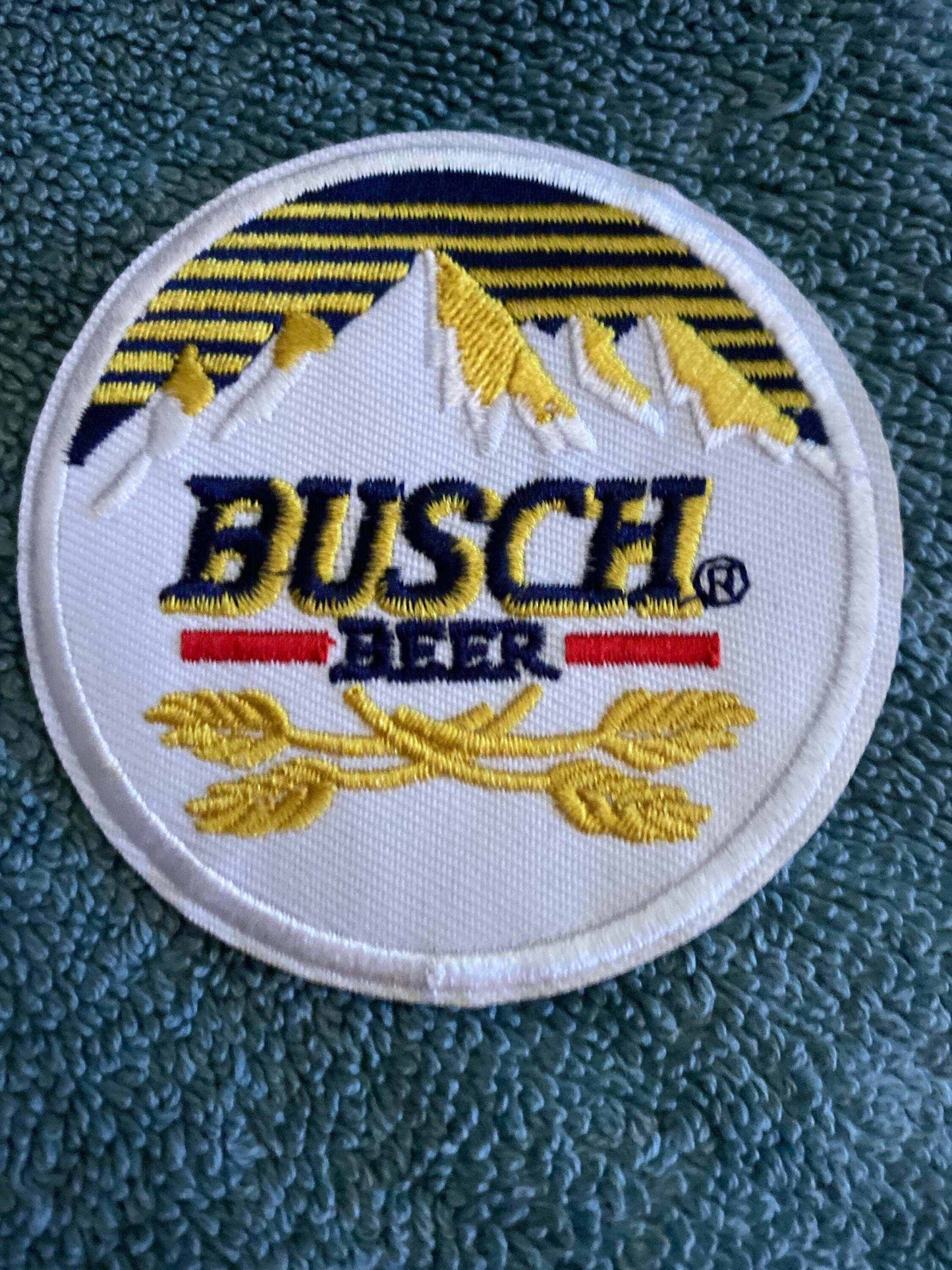Busch Beer embroidered patch with mountain and wheat design on textured fabric background