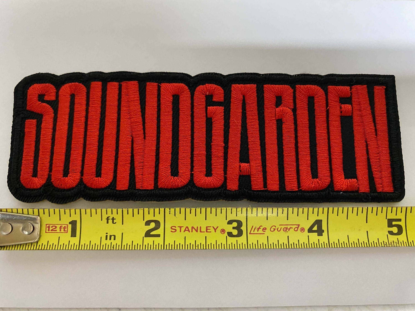 Embroidered Soundgarden patch with red logo on black background measuring about 4.5 inches wide