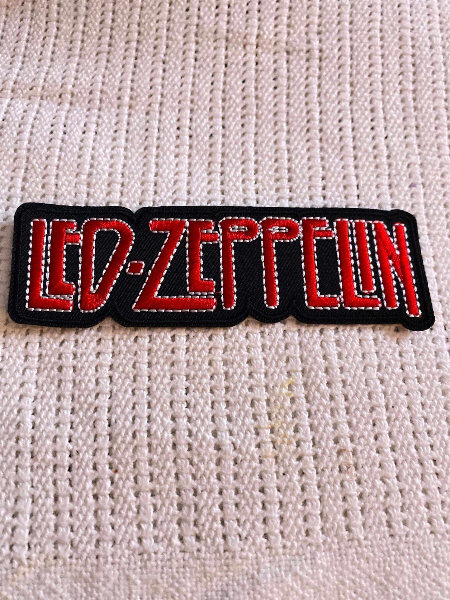 LED-ZEPPELIN logo embroidered patch in red and black on textured fabric background