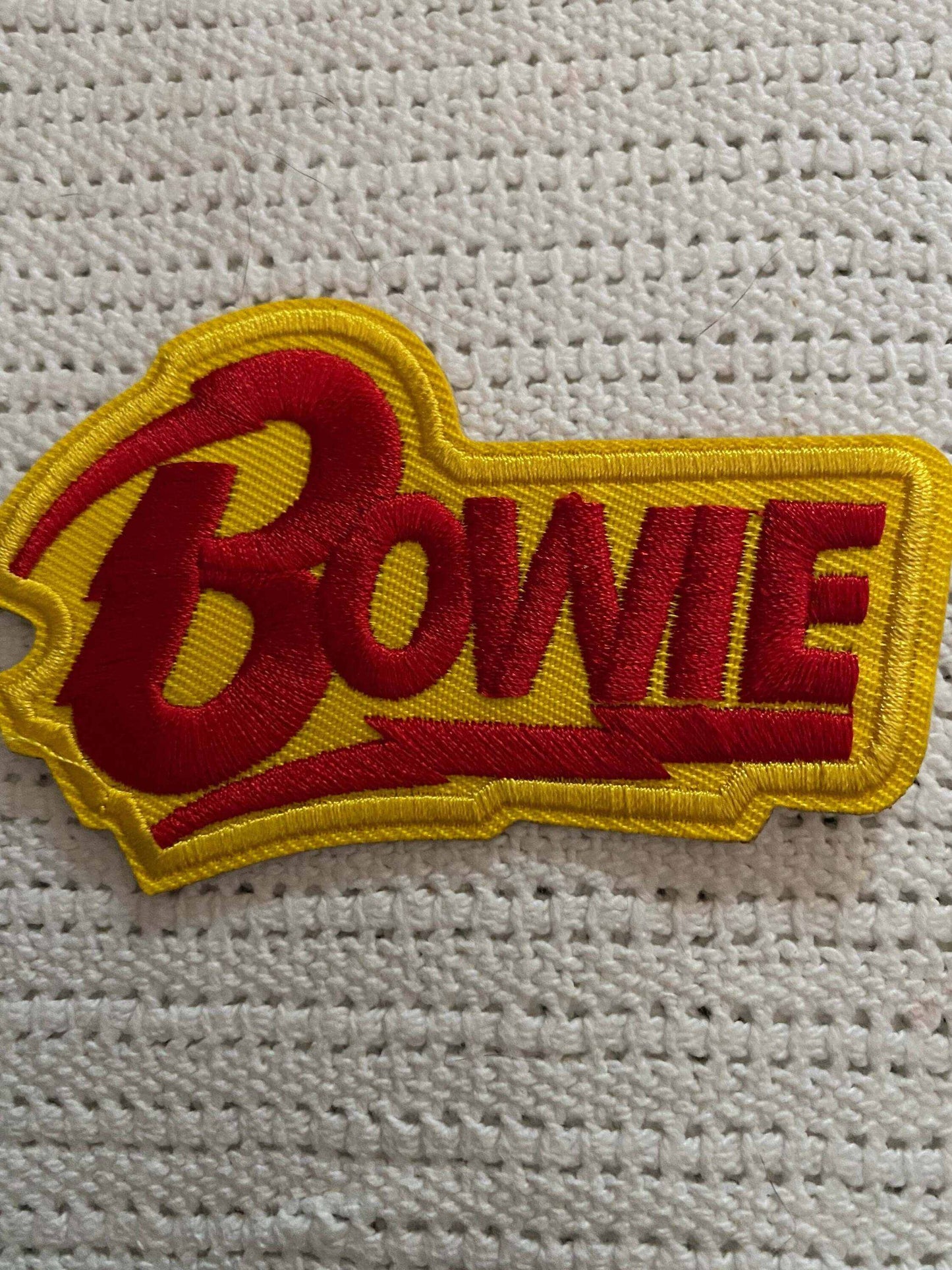 Embroidered David Bowie patch with red lettering on yellow background for fans and collectors
