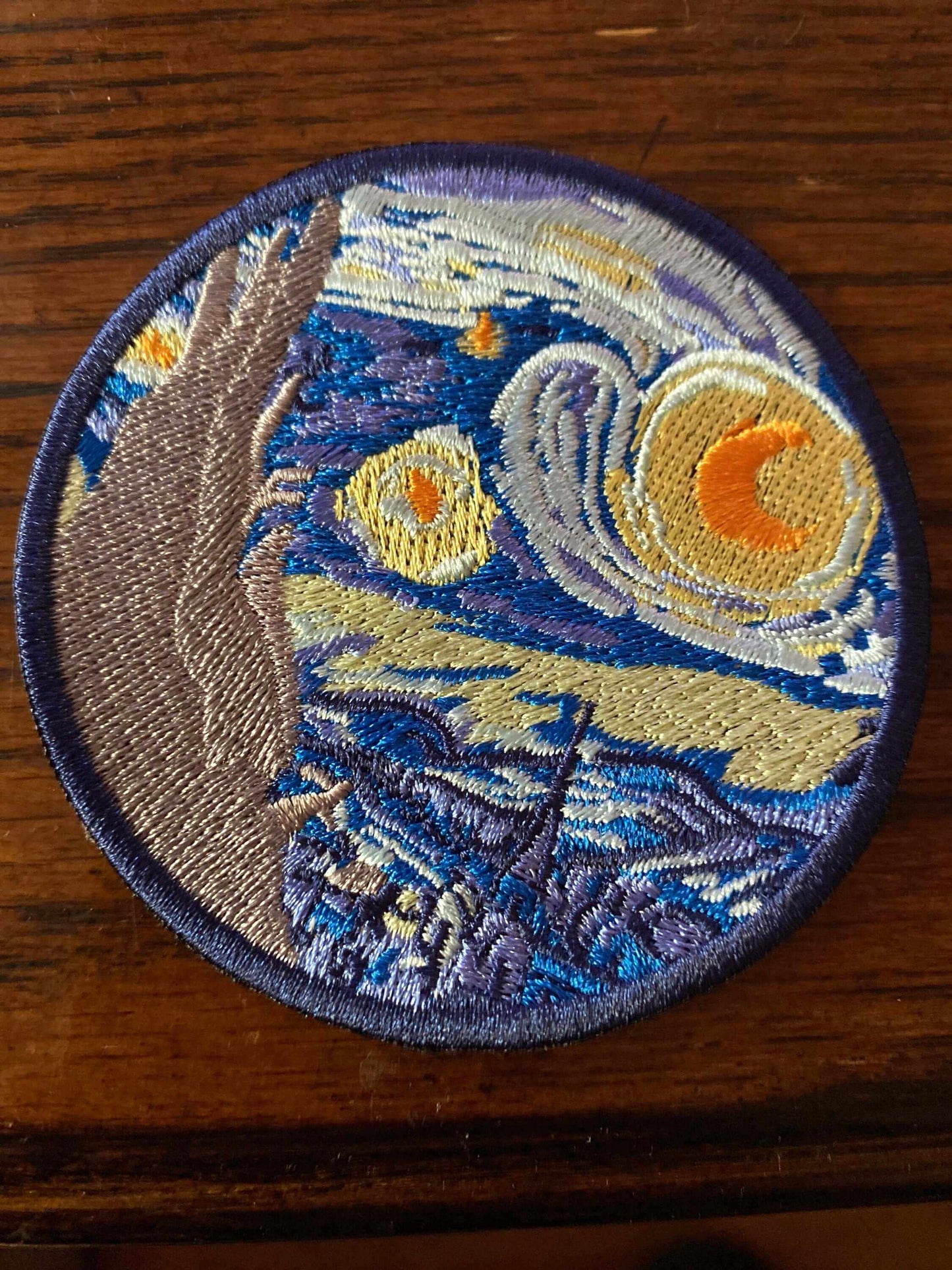Embroidered patch of Starry Night Van Gogh showing swirling night sky and village in vibrant colors