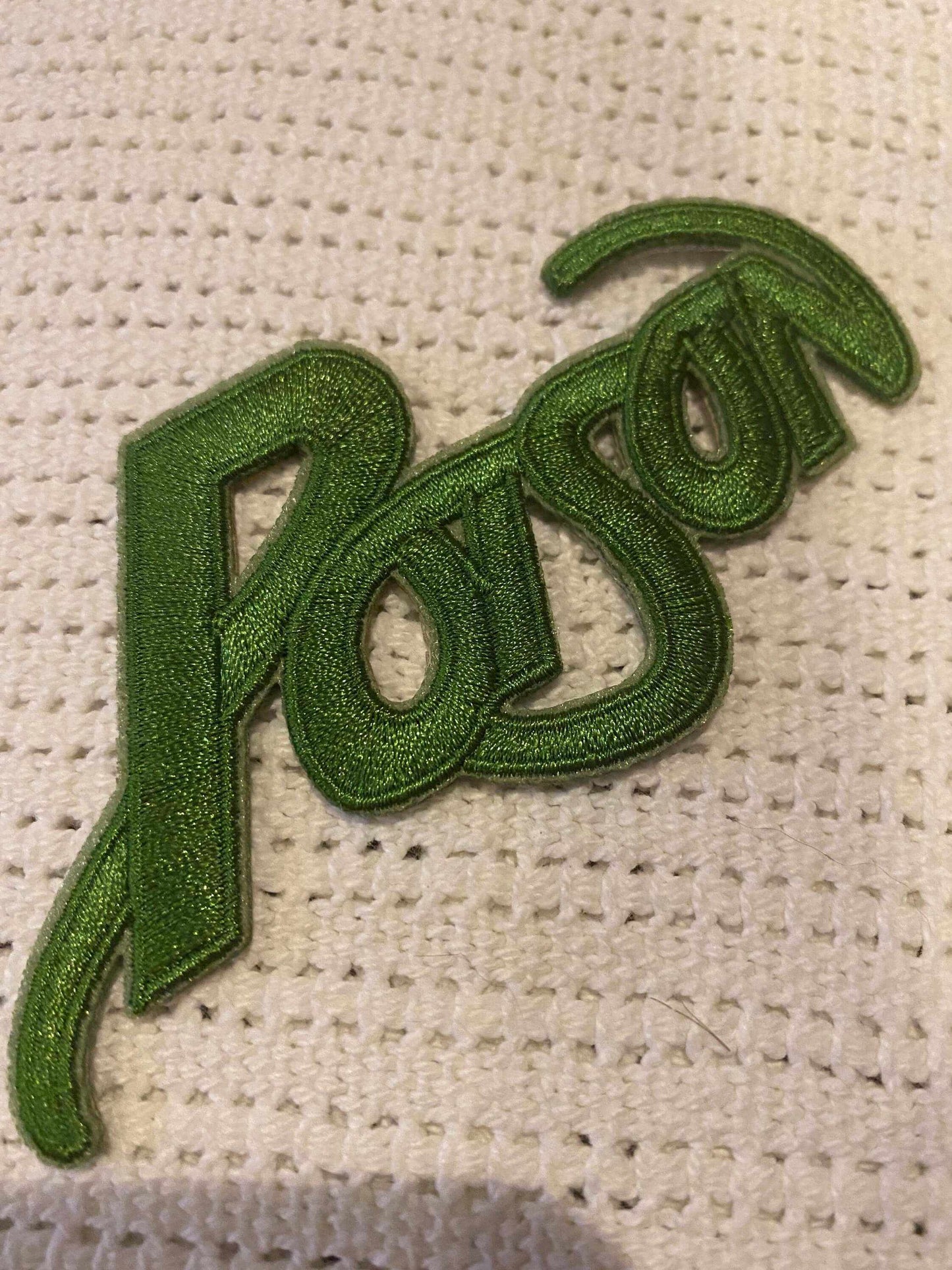Green embroidered patch with the word "Poison" in stylized script design