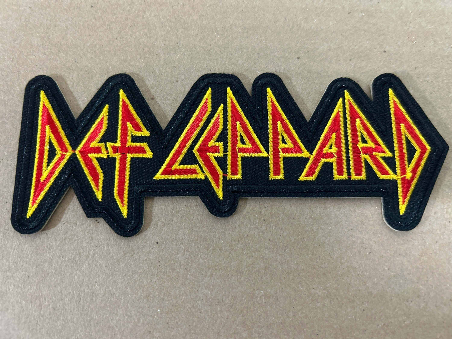 Def Leppard patch with iconic yellow and red band logo on black background