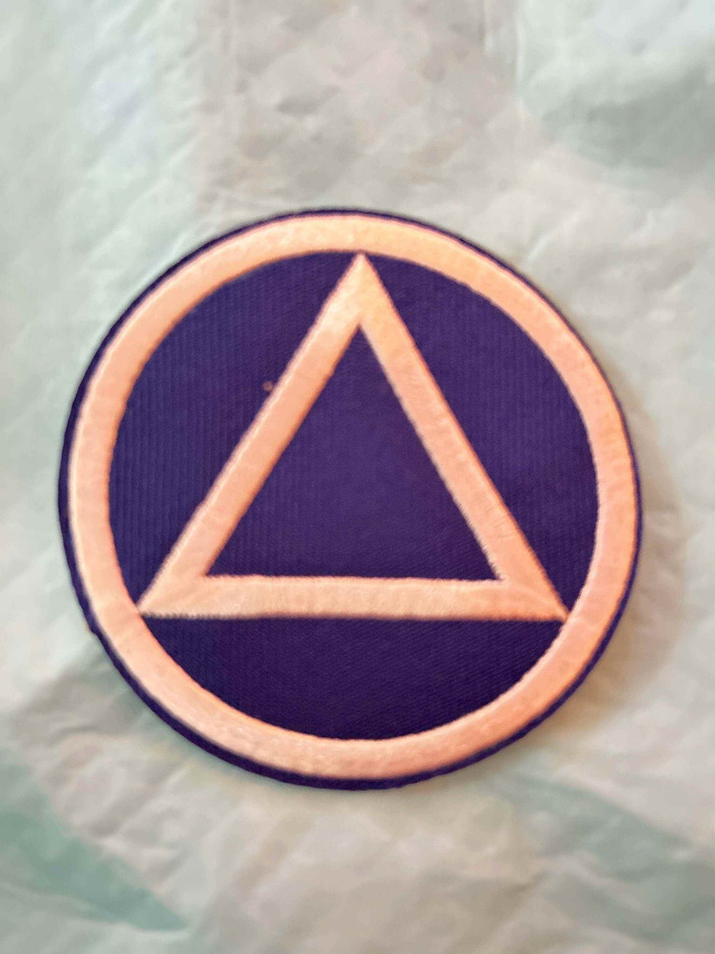 Circle and Triangle patch in purple and beige representing unity and balance, embroidered geometric design.