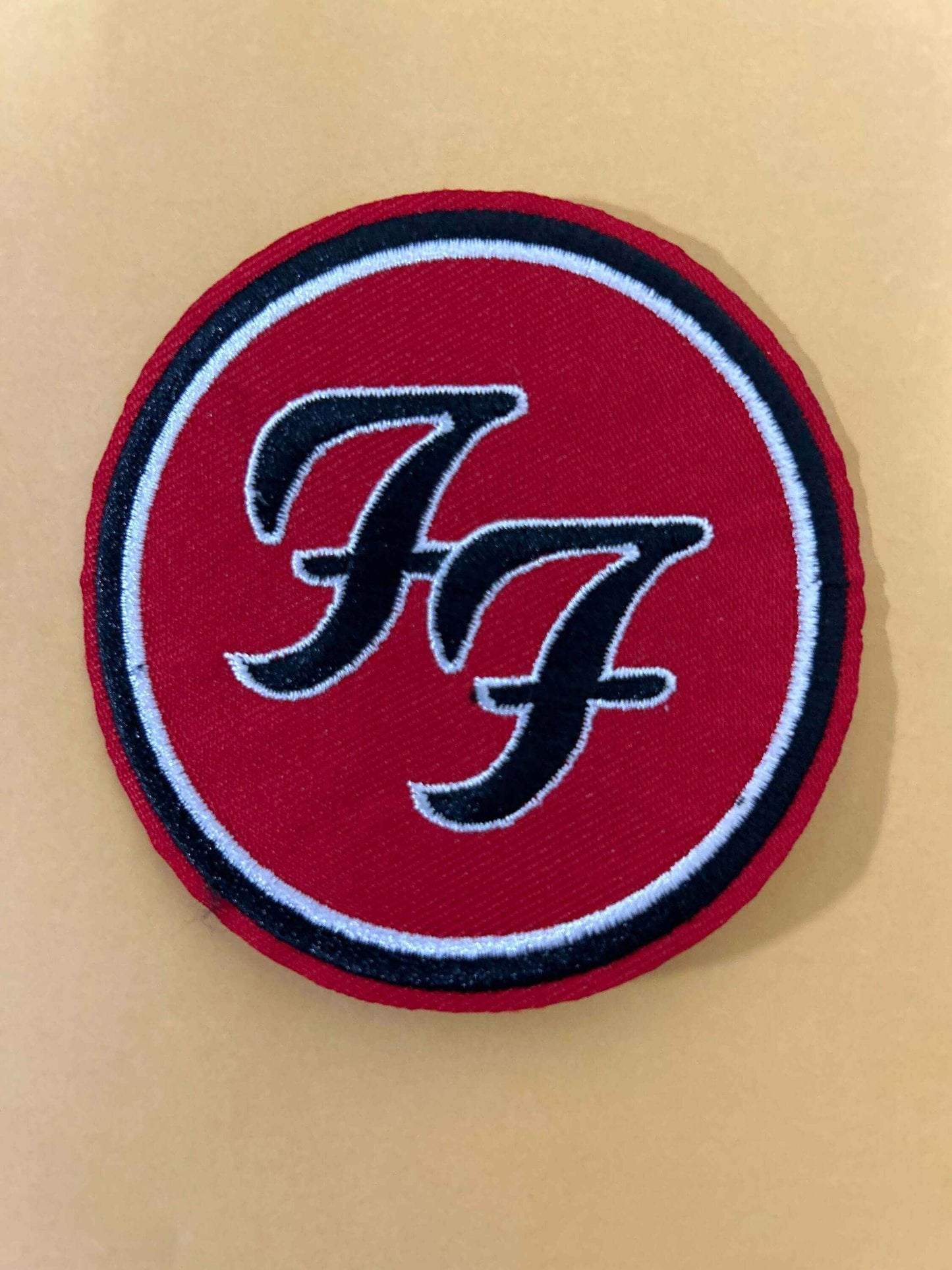 Foo Fighters patch with red background and black and white double "F" logo embroidered in circular design