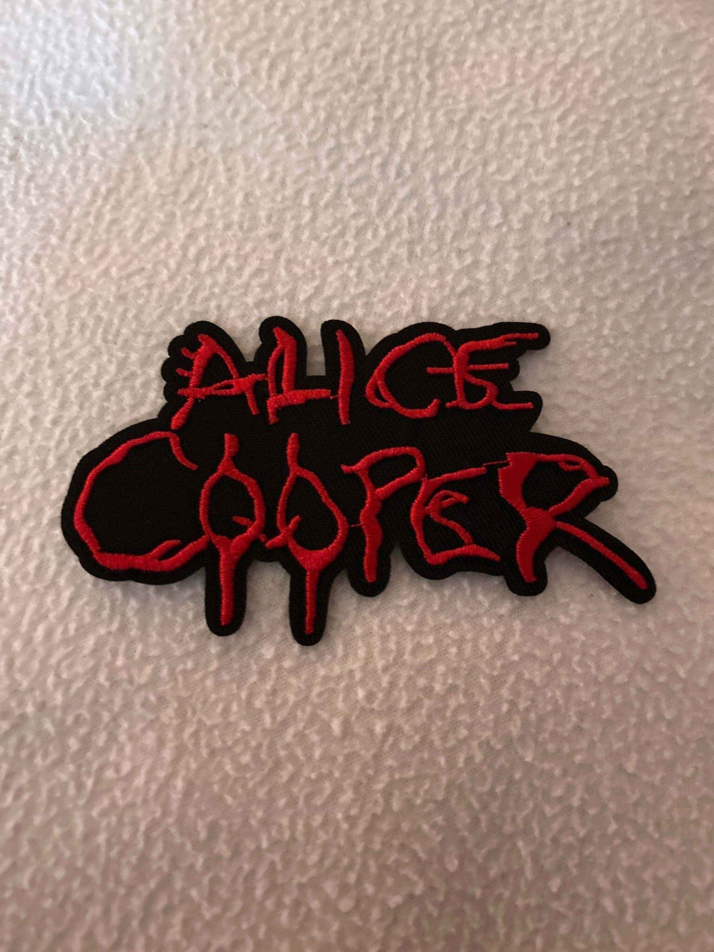 Alice Cooper patch with red lettering on black background showcasing rock rebellion design
