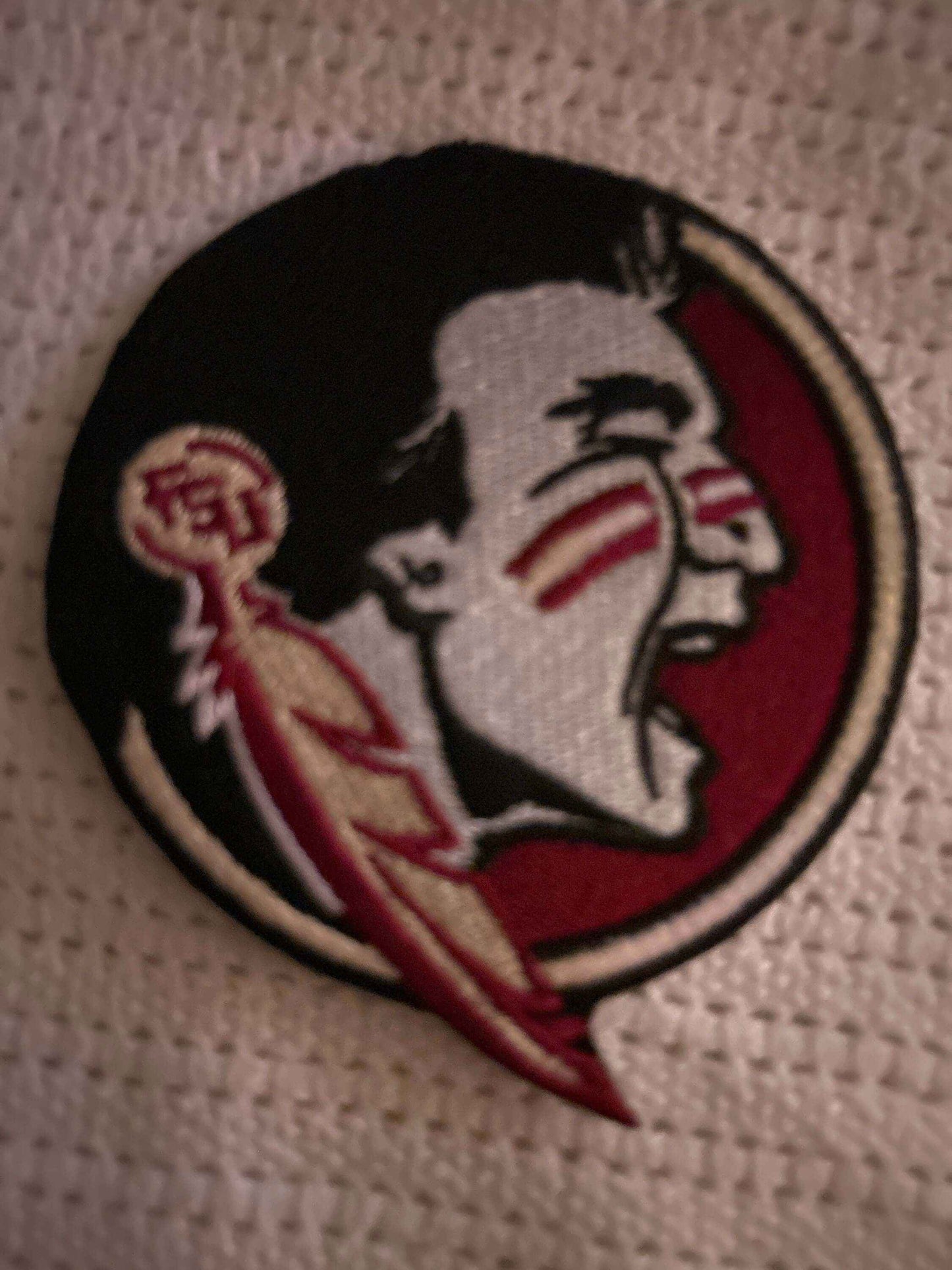 Florida Seminoles logo patch with a Native American profile in red, black, and white colors