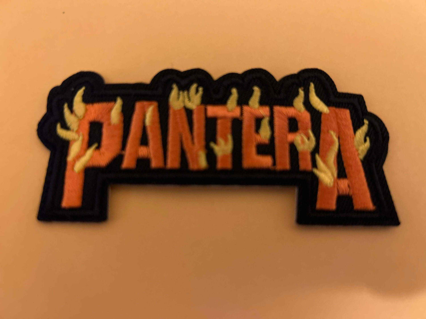 Pantera metal rock band embroidered patch with orange letters and yellow flames on black background
