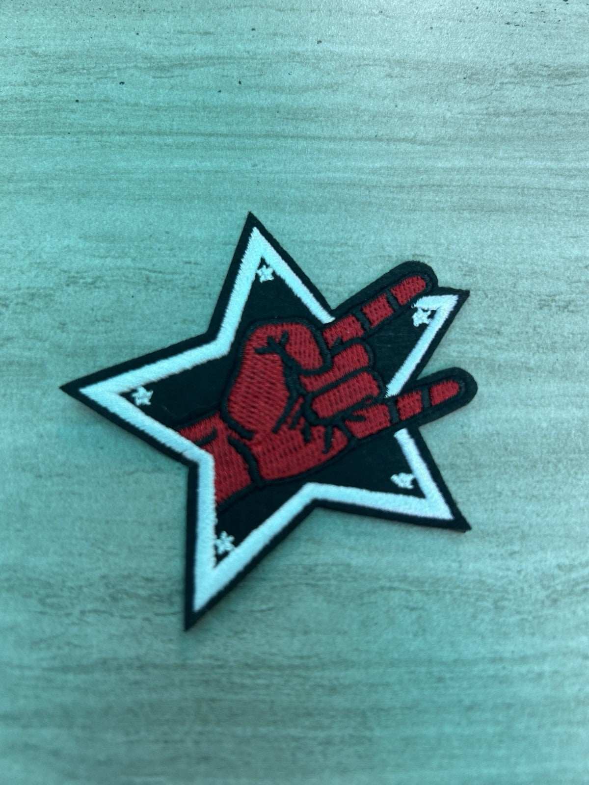 Star brand embroidered iron-on patch featuring a heavy metal hand gesture symbol