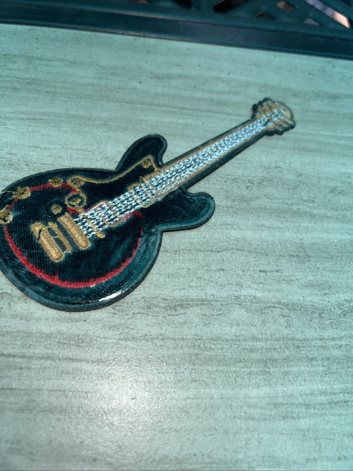 Red electric guitar embroidered iron-on patch for music-themed apparel and accessories