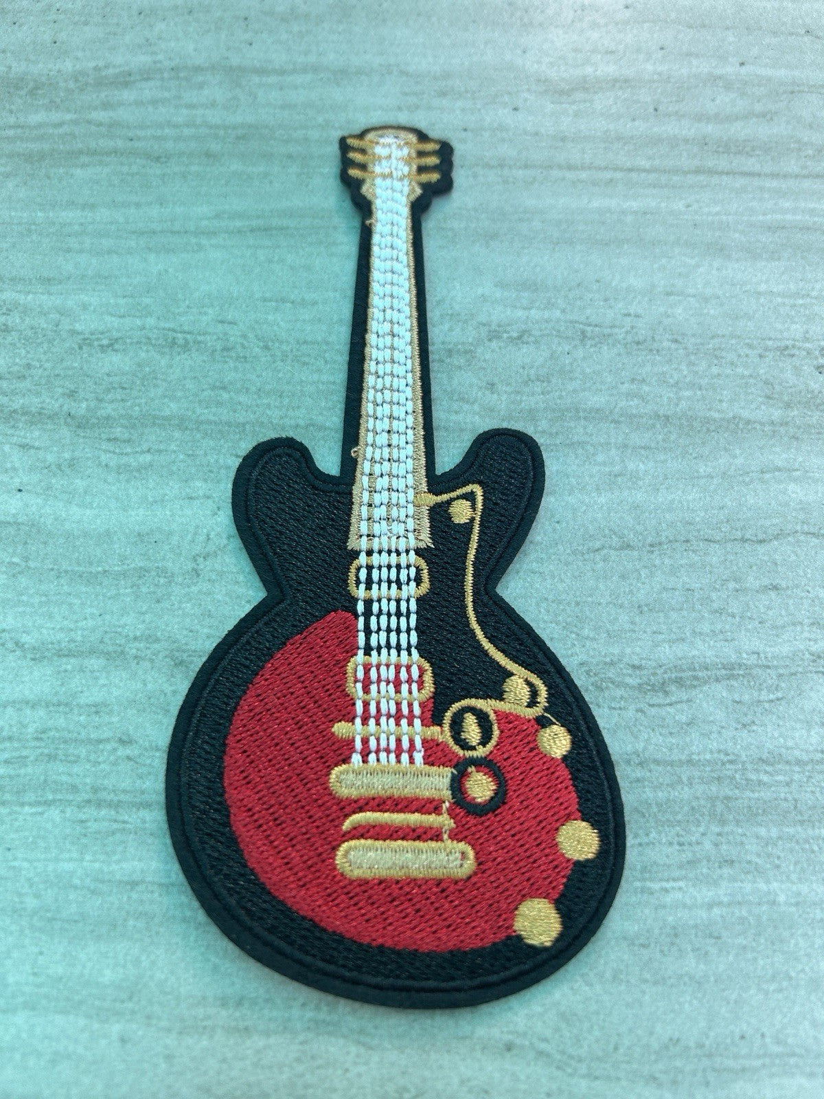 Red electric guitar embroidered iron-on patch for music-themed crafts